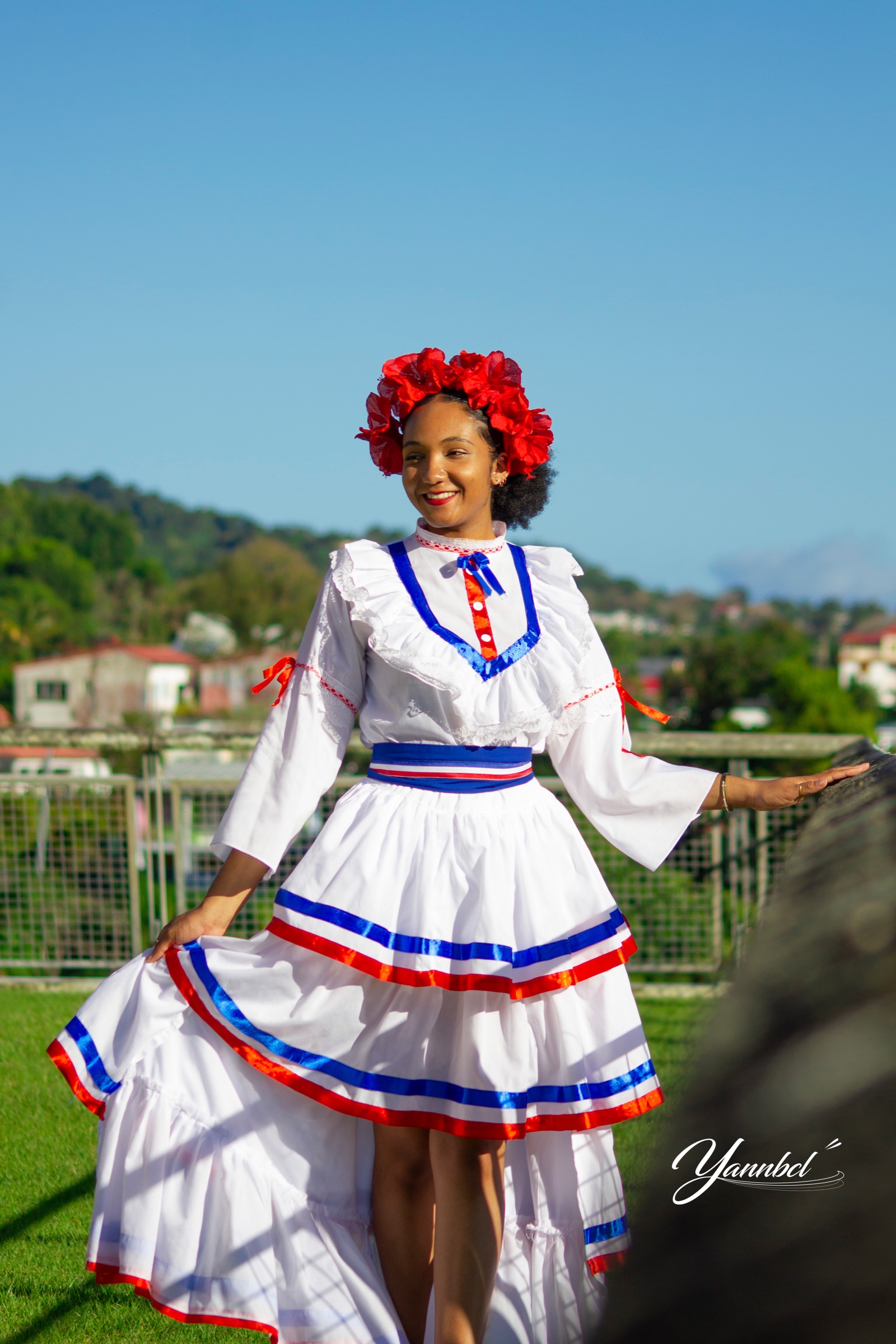 Portrait d’une femme en tenue traditionnelle blanche, rouge et bleue