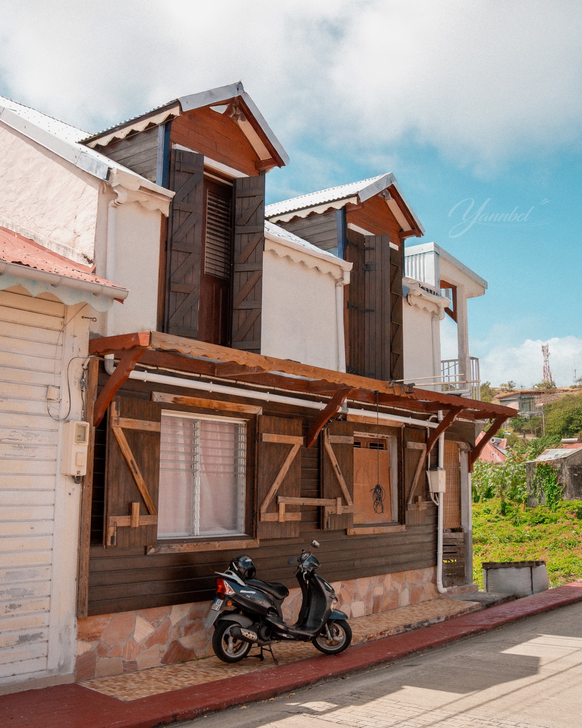 Maison traditionnelle en bois et scooter à Terre-de-Bas