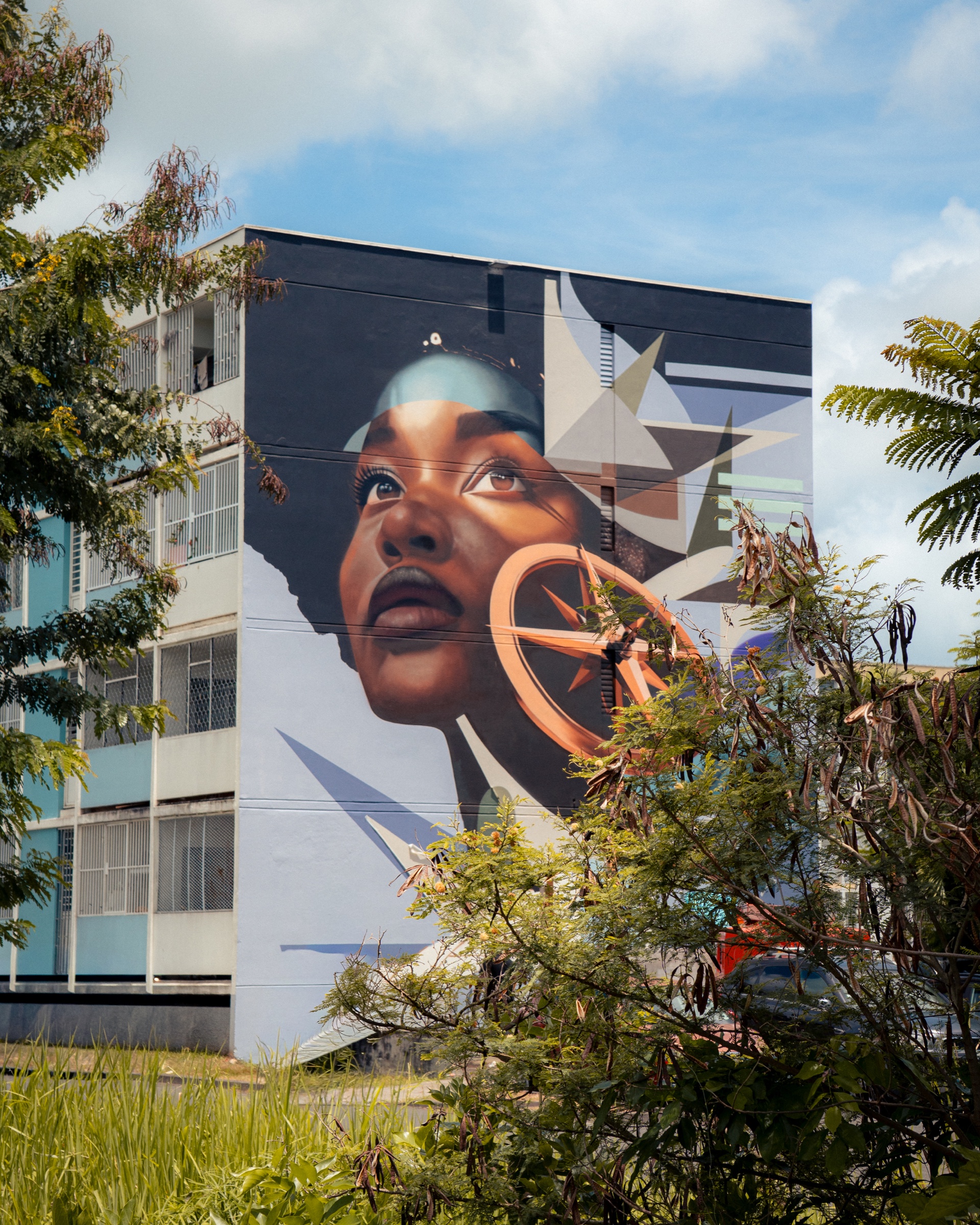 Portrait mural monumental entouré de végétation tropicale