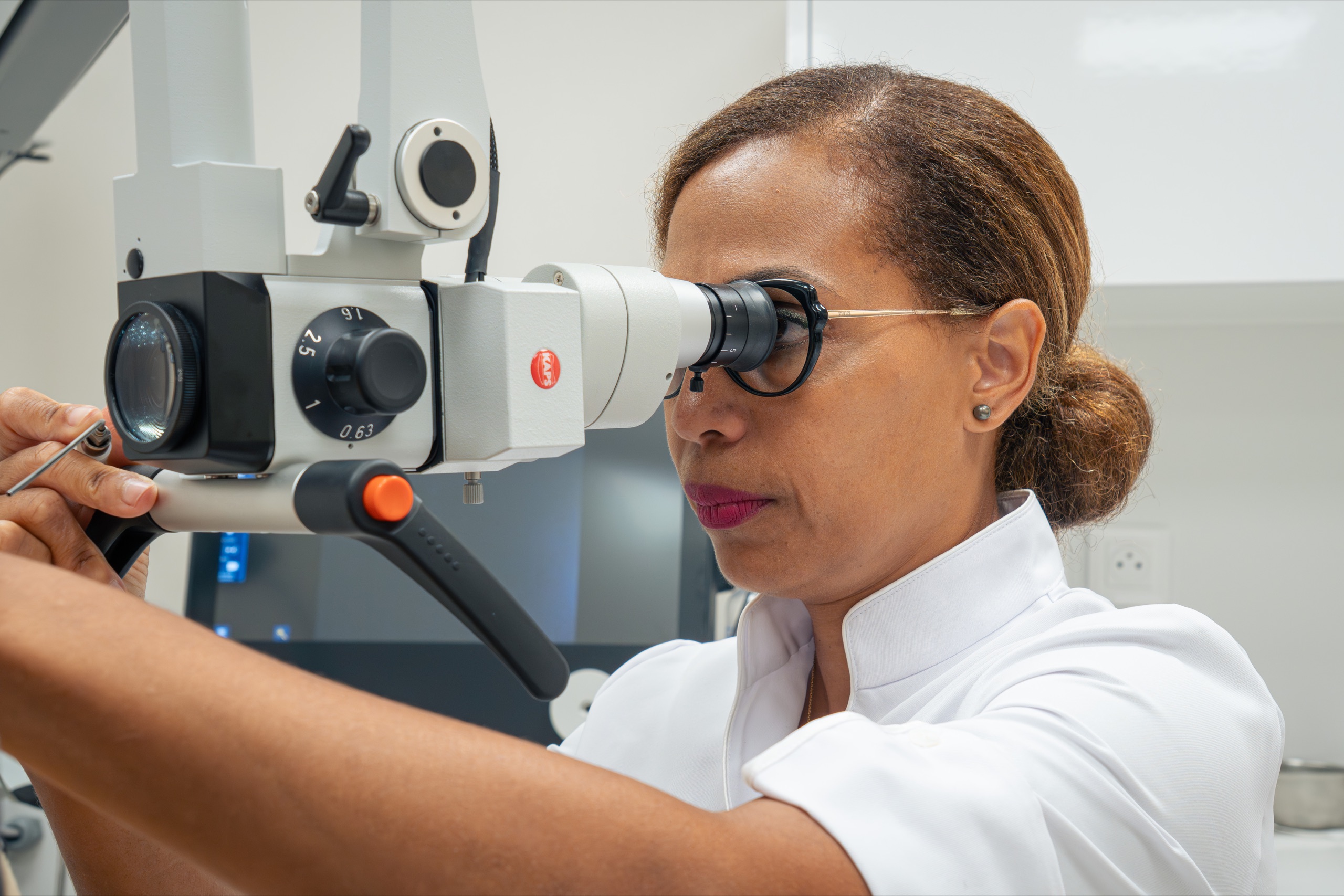 La praticienne utilise un microscope médical pendant une consultation